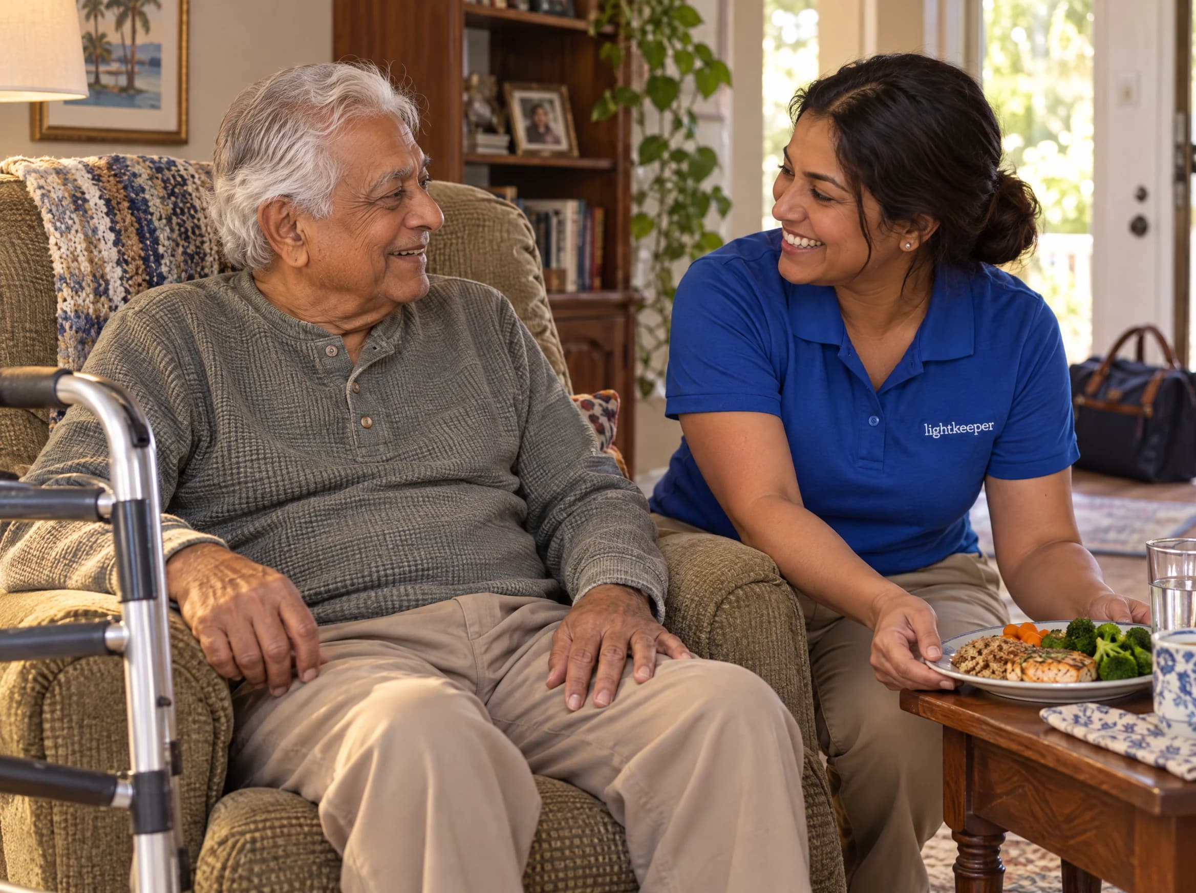A Lightkeeper helps an older man settle comfortably at home with a prepared lunch